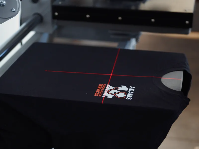 DTF transfer being pressed onto dark fabric with laser alignment