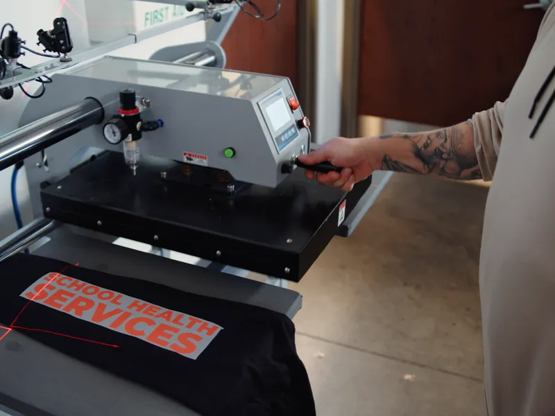 Operator pressing custom shirt with DTF transfer